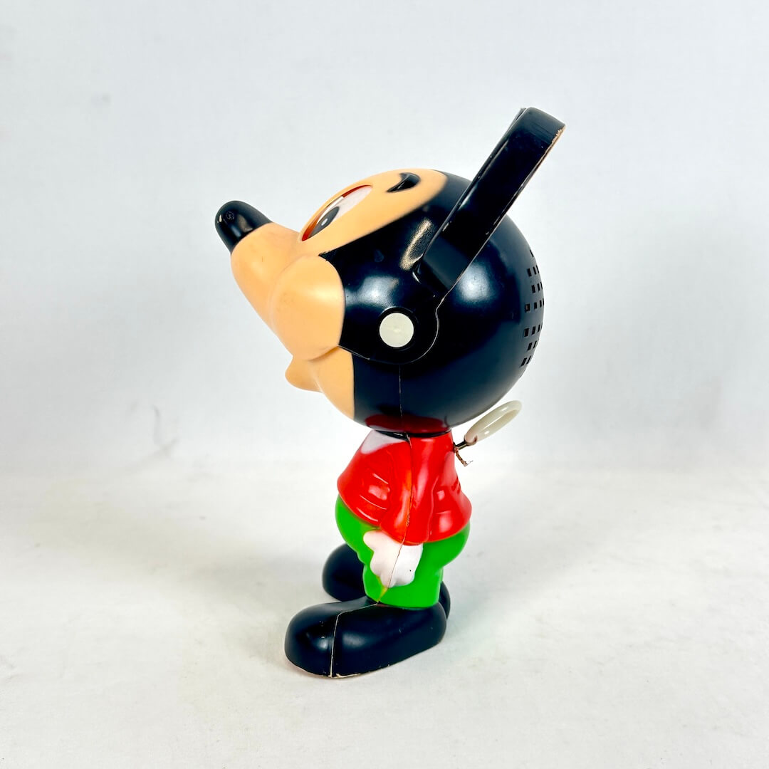 Vintage toy figure of a character with a black hat and red shirt on a white background