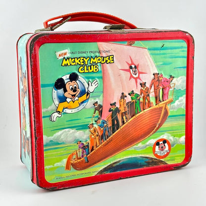 Vintage lunchbox with red border and handle with image of ship with Mickey Mouse Club members on it. 