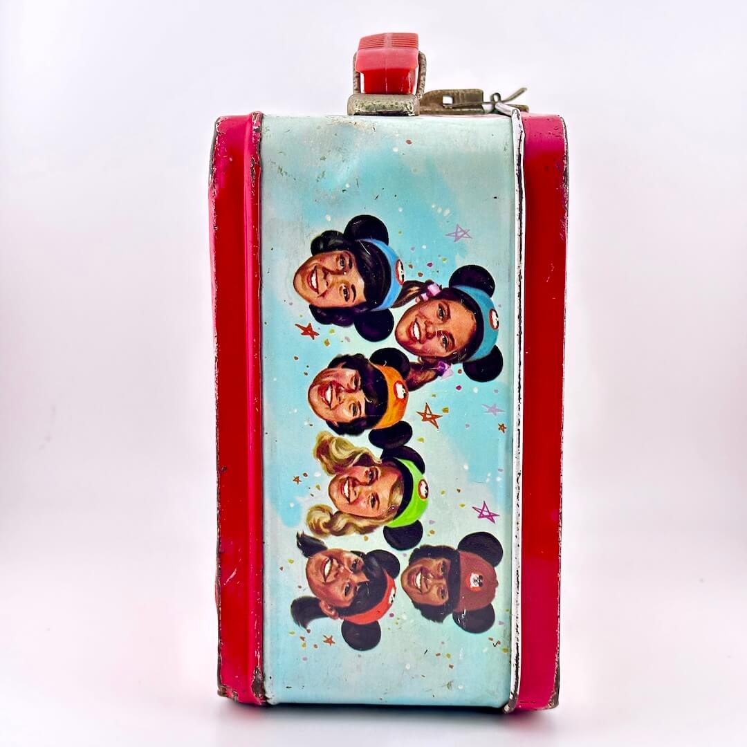 Side view of metal lunchbox with images of children's faces wear Mickey Mouse ears. 