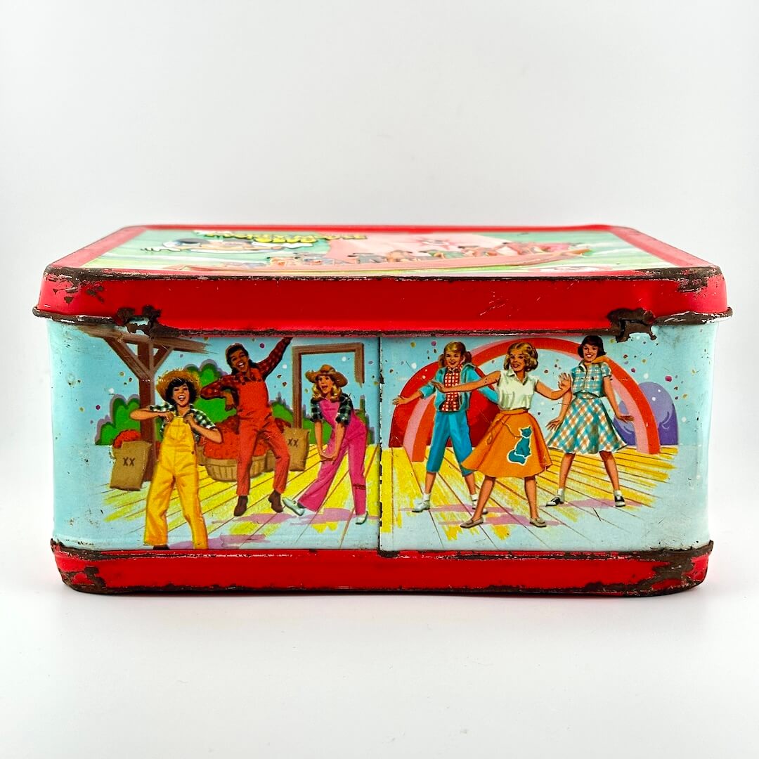 Bottom view of metal lunchbox with image of dancing children in western wear. 