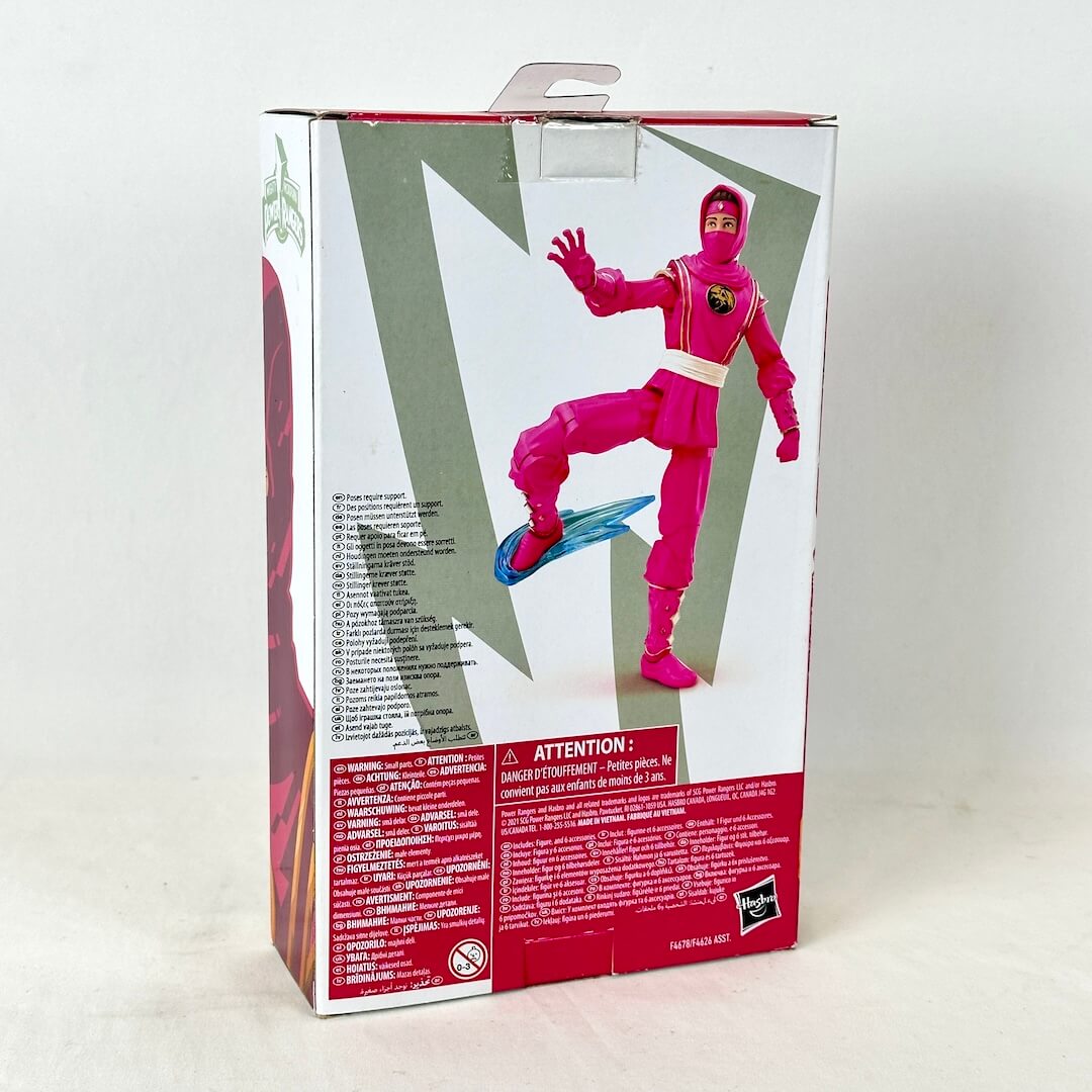 Back of packaging with image of posed action figure with warning labels and product information. 
