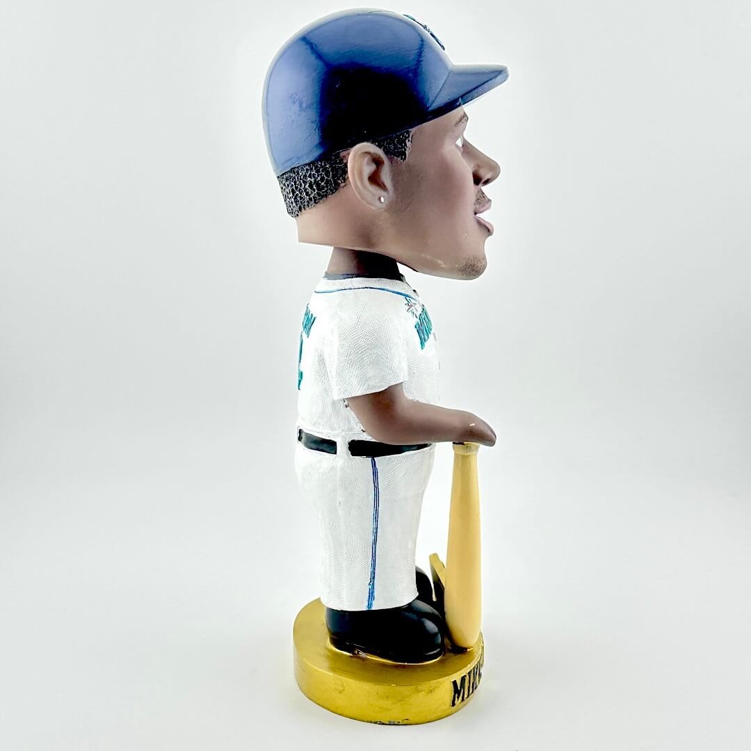 Bobblehead of a baseball player in a white uniform with blue accents, holding a bat, on a white background.