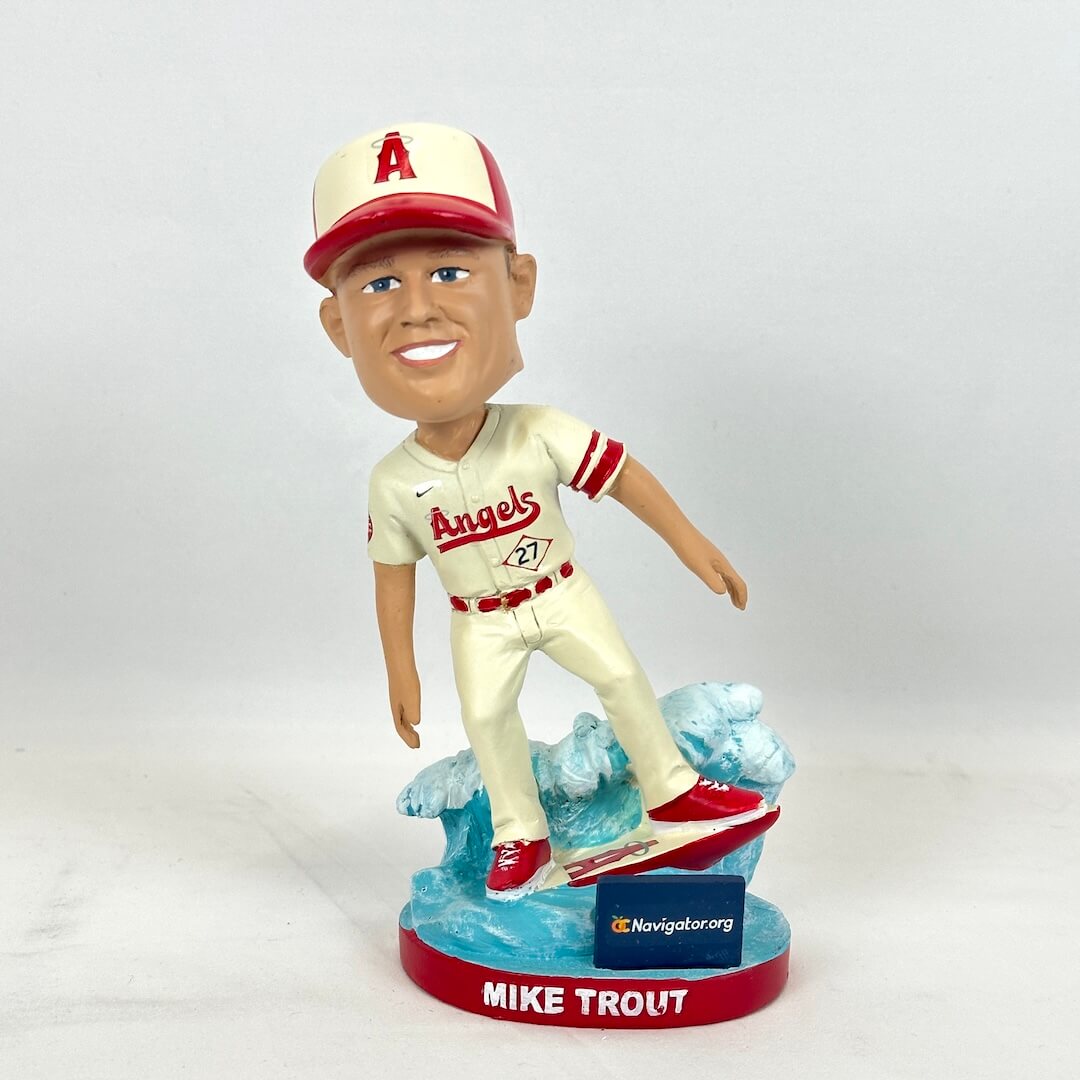 A Mike Trout bobblehead figurine wearing a Los Angeles Angels baseball uniform, standing on a blue wave-like base.