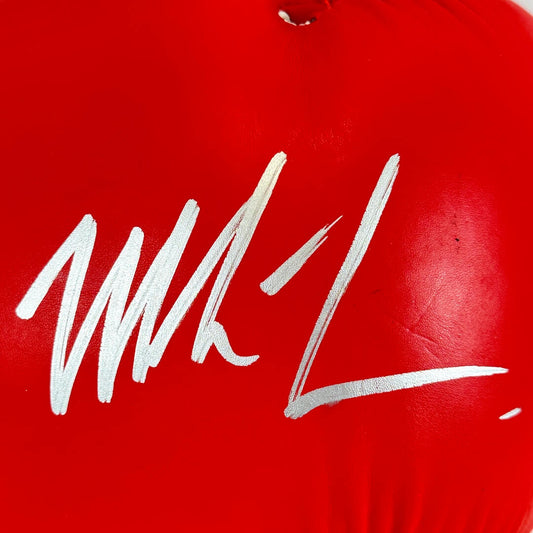 Red boxing glove with a white signature on a red background