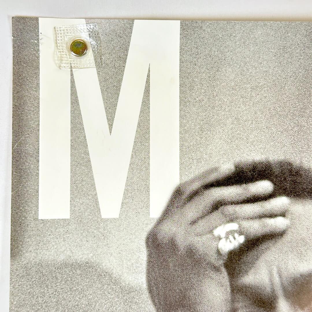 Top left corner of poster with pin holes. 