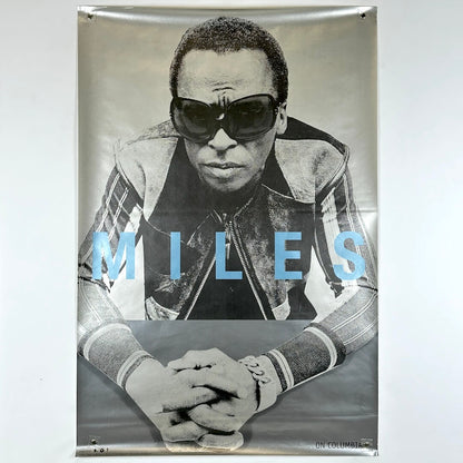 Poster of a person wearing sunglasses with 'MILES' text on a gray background