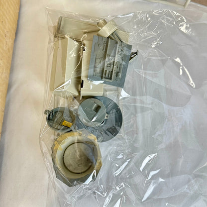 Gray and beige model parts in clear plastic bag