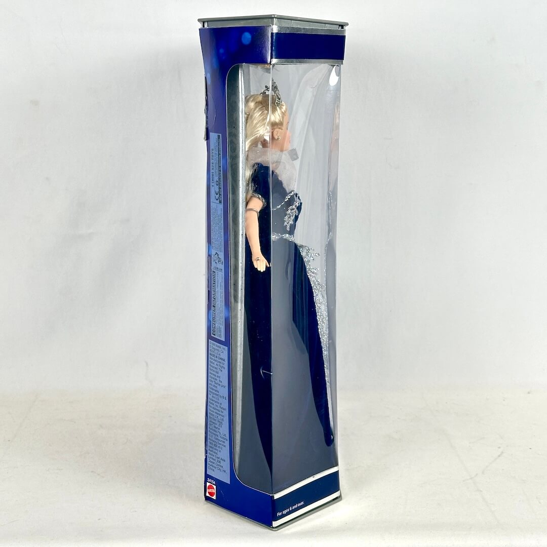 Doll in a blue and silver box on a white background