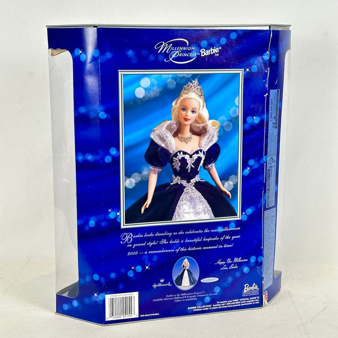 Barbie doll in a blue and silver dress with a tiara, encased in a blue packaging box.