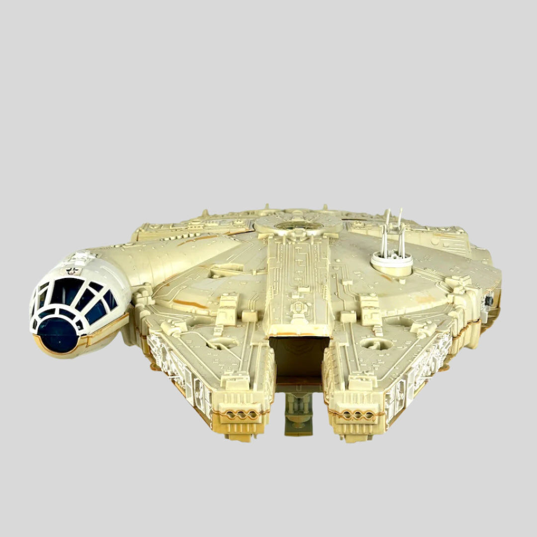 Millennium Falcon toy against light gray background. 
