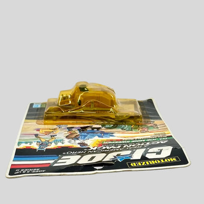 Toy figure in clear plastic packaging on a colorful card background