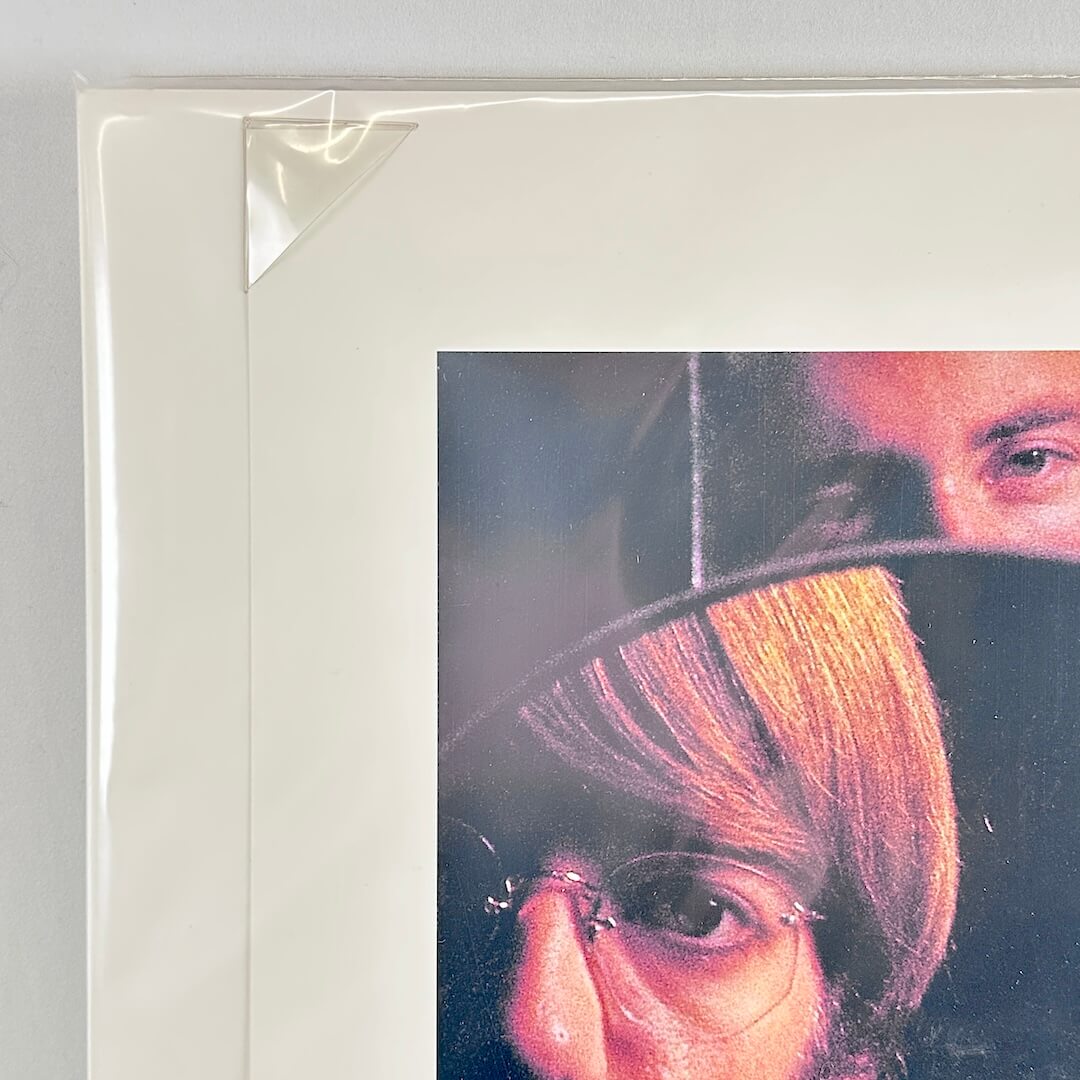 Top left corner of print tucked into protective corner, sleeved in plastic. 