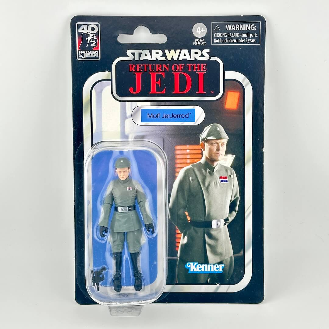 Star Wars action figure in its original blister packaging with retro-style card back; figure in all gray uniform. 