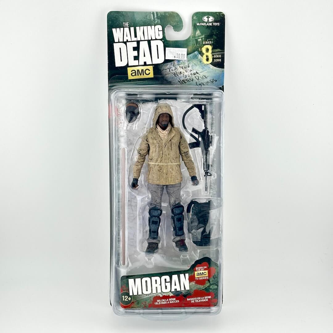The Walking Dead Morgan action figure in its original blister packaging. Figure in a beige hooded jacket, & gray pants.