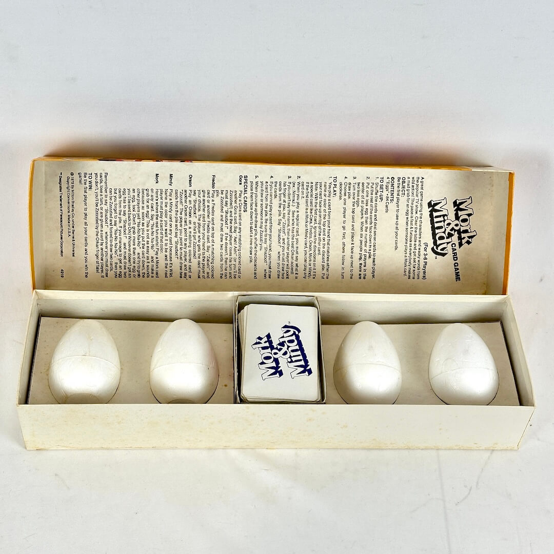 Set of white ceramic eggs with a decorative box on a light gray background