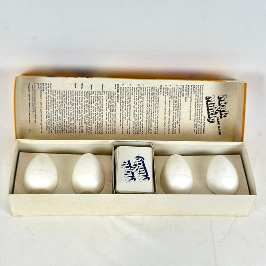 Set of white ceramic eggs with a decorative box on a light gray background