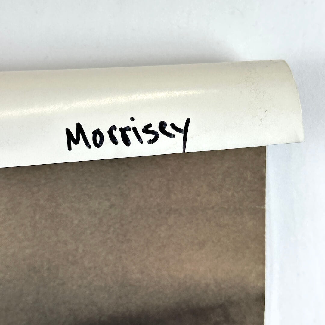 Top right corner rolled down to show artist name written in black marker. 