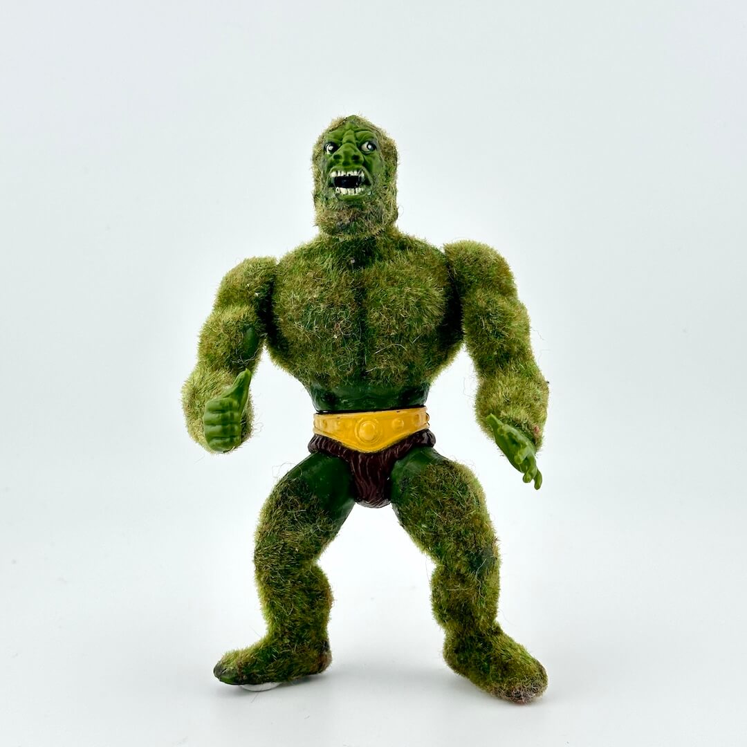 Green flocked action figure against white background.