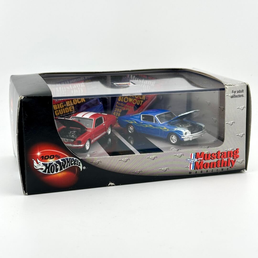 A boxed set of two diecast Mustang cars in a clear-front retail package, showing cars with their hoods propped open. 