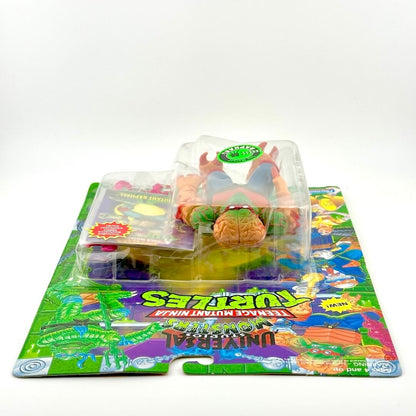 Toy figure in packaging on a colorful mat with 'Teenage Mutant Ninja Turtles' branding.
