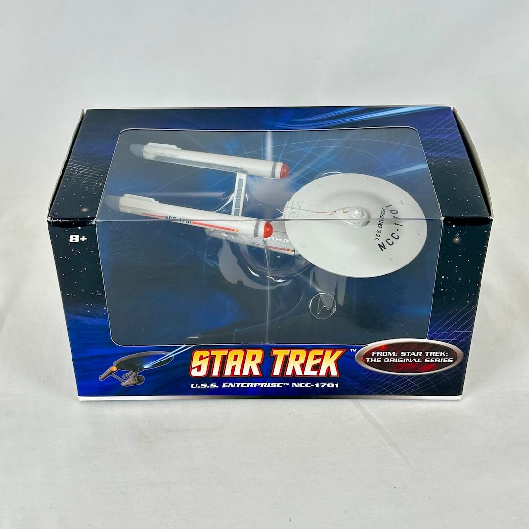 Toy spaceship model in packaging against white background.