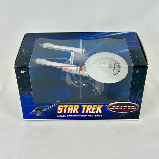 Toy spaceship model in packaging against white background.