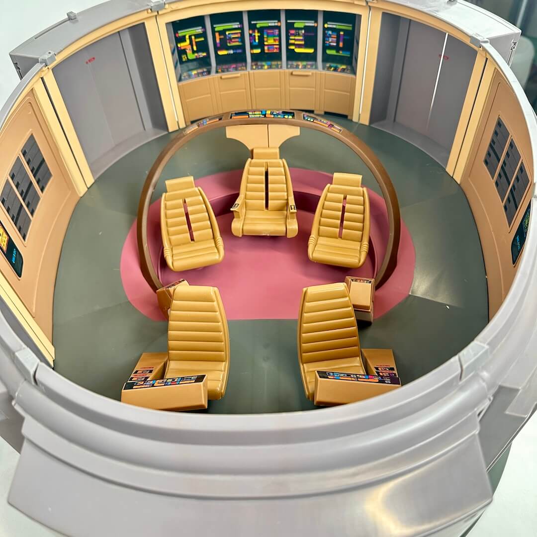 Model of a futuristic control room with yellow chairs and electronic panels.