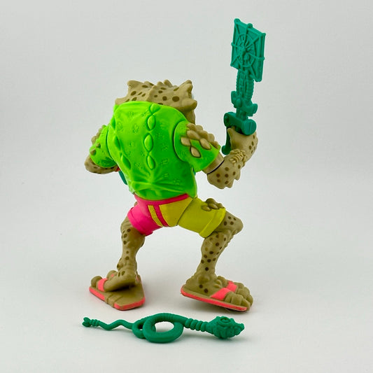 Anthropomorphized frog action figure wearing yellow & pink shorts, with three teal accessories, back view.