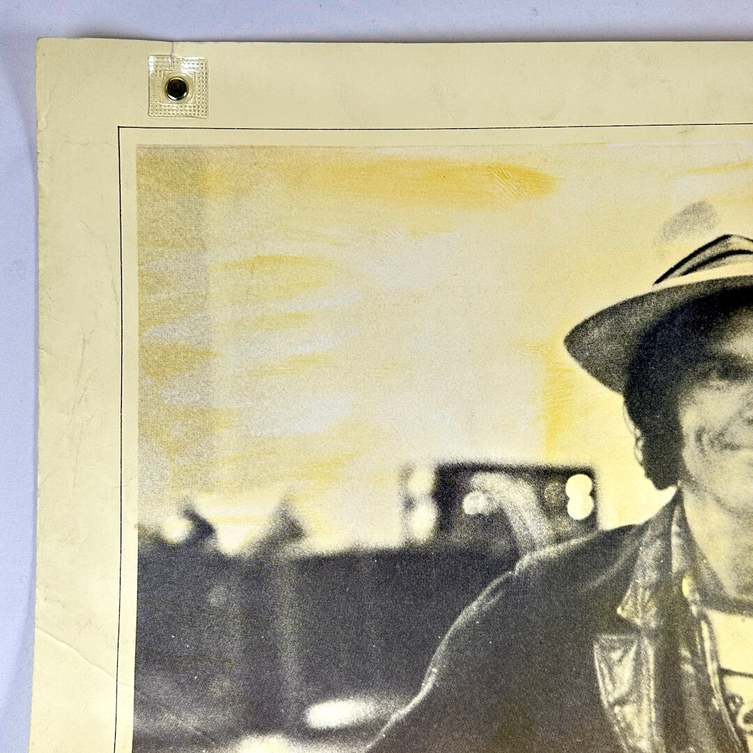 Top left corner of poster with edge wear along long side. 