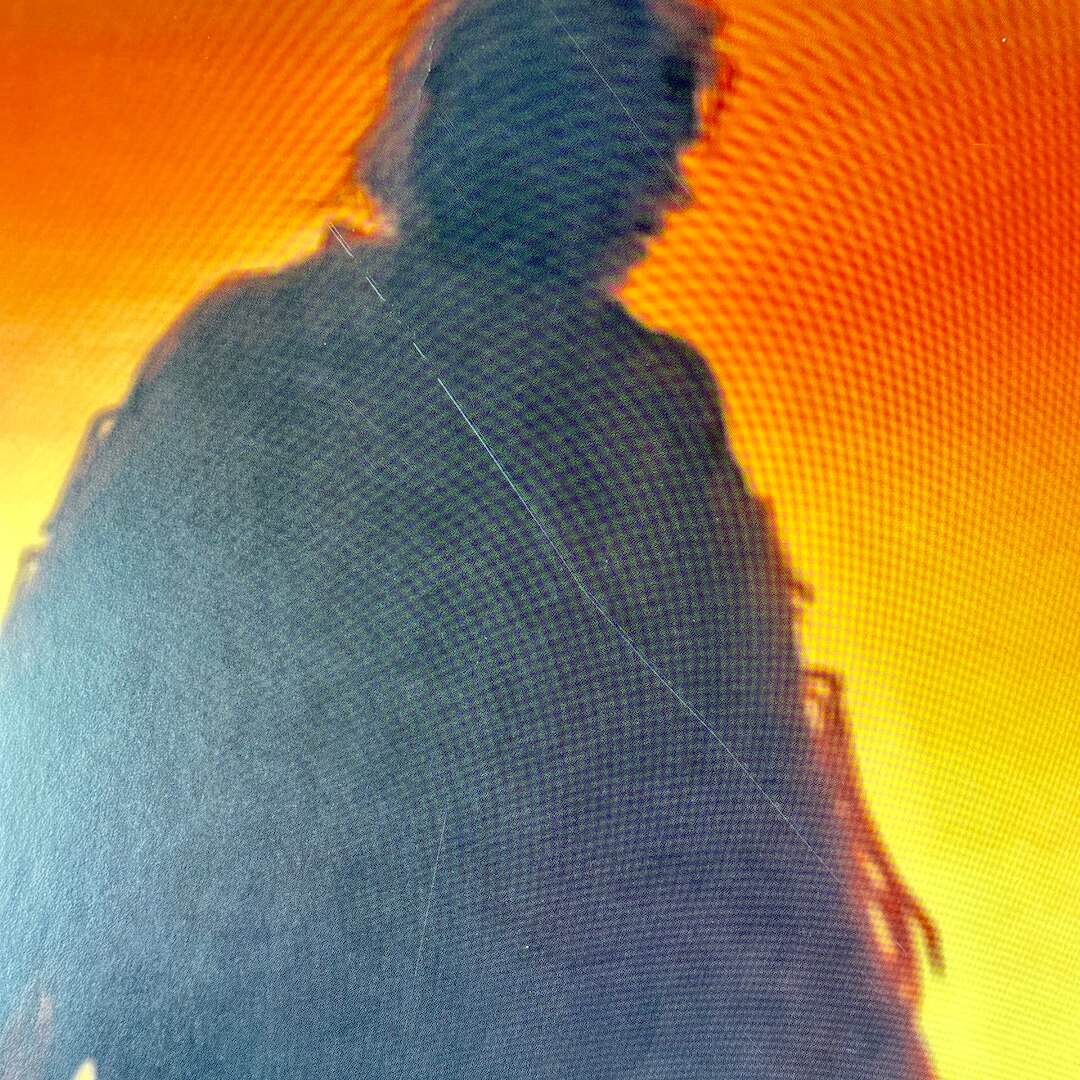 Silhouette of a person against a bright orange background
