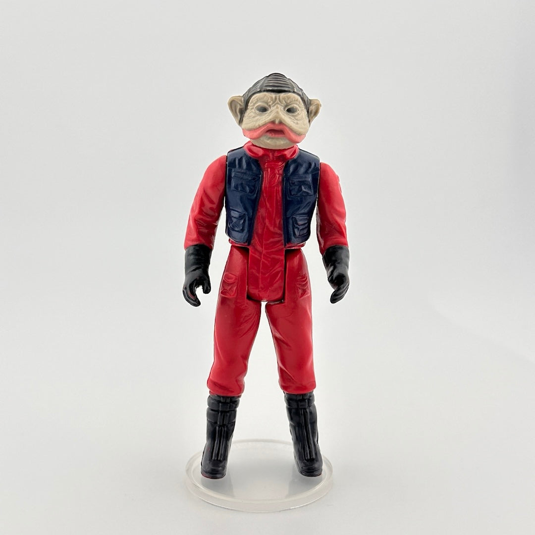 Image of 3-inch alien figure with grey wrinkled skin & pink mouth in a red flight suit, navy vest, black boots and gloves.