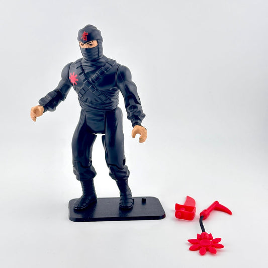 Black action figure with a red emblem on a white background
