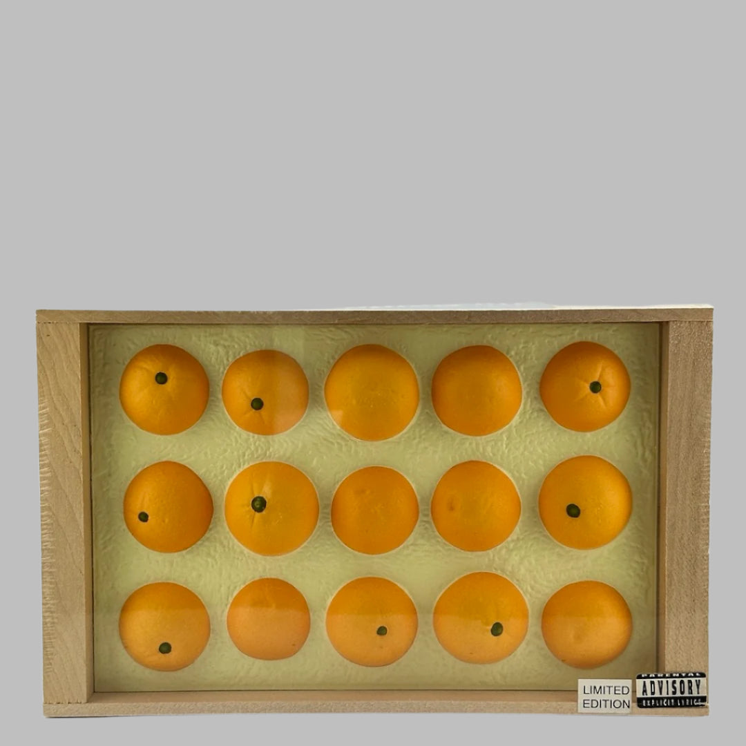 Plastic wrapped wooden fruit crate with blue label on side, & fake oranges in top. Top view.