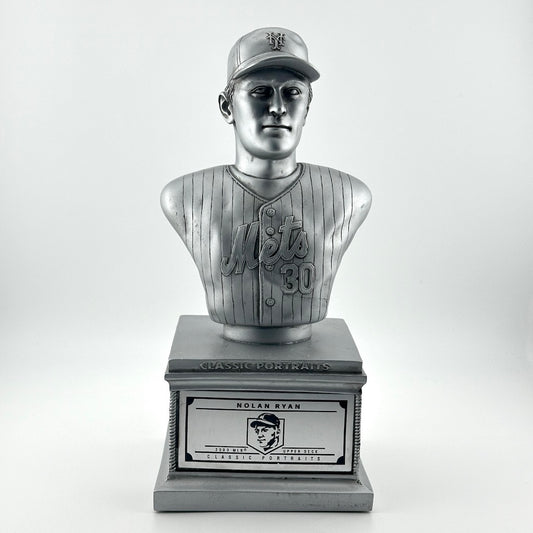 Silver pedestal with silver bust of Nolan Ryan in NY Mets uniform. Silver plaque on pedestal.
