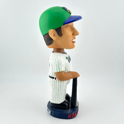 Bobblehead figure of a baseball player wearing a green and blue cap on a white background