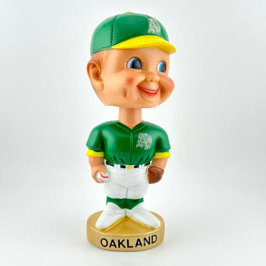 Bobblehead figure in green Oakland sports uniform on a white background