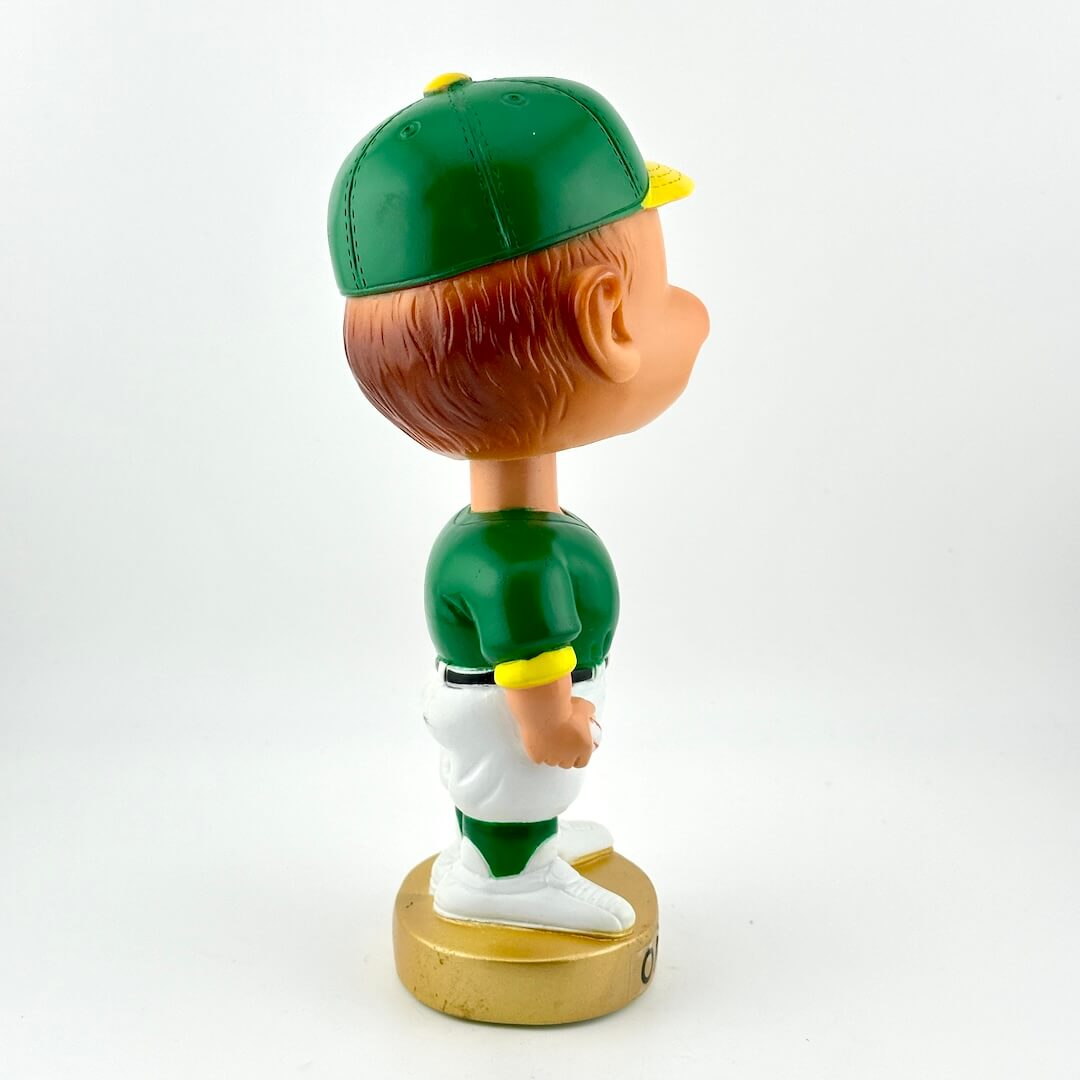 Bobblehead figure in a green sports uniform on a white background