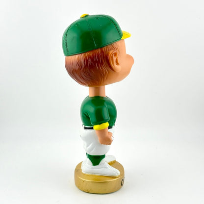 Bobblehead figure in a green sports uniform on a white background
