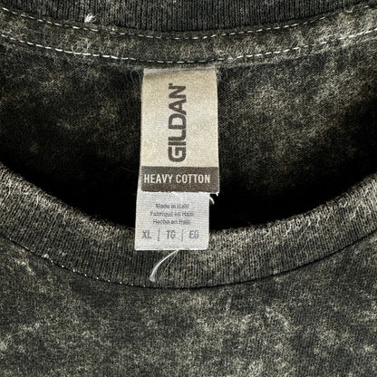 Close-up of a Gildan heavy cotton t-shirt showing the inner neck label and the dark gray mineral-wash fabric texture.