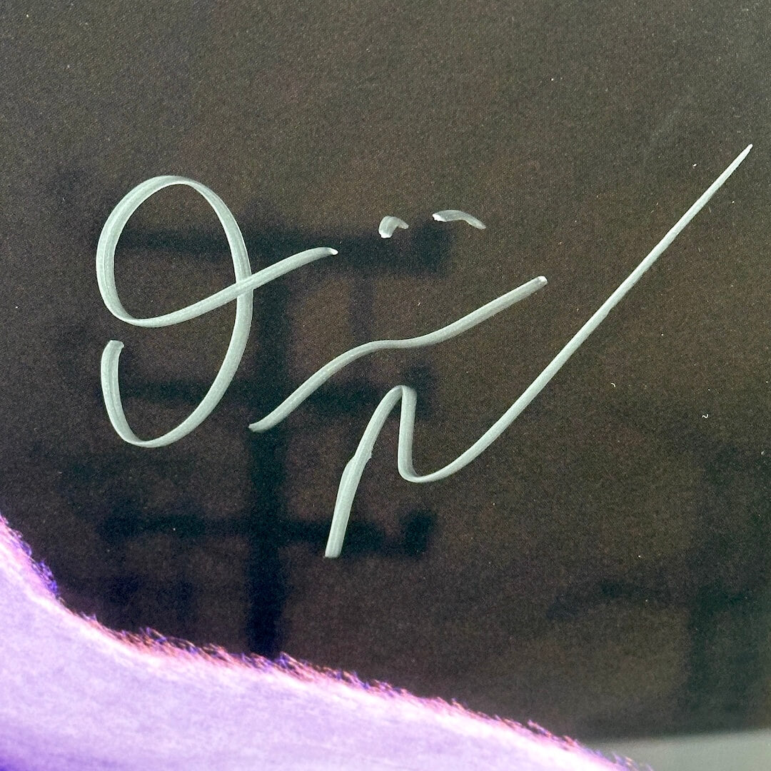 Close up of silver marker signature on dark background.