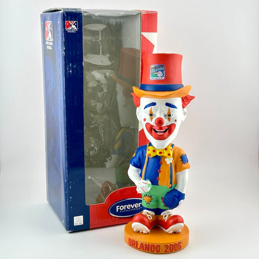 Colorful clown figurine with a top hat and bow tie, standing next to a branded box.