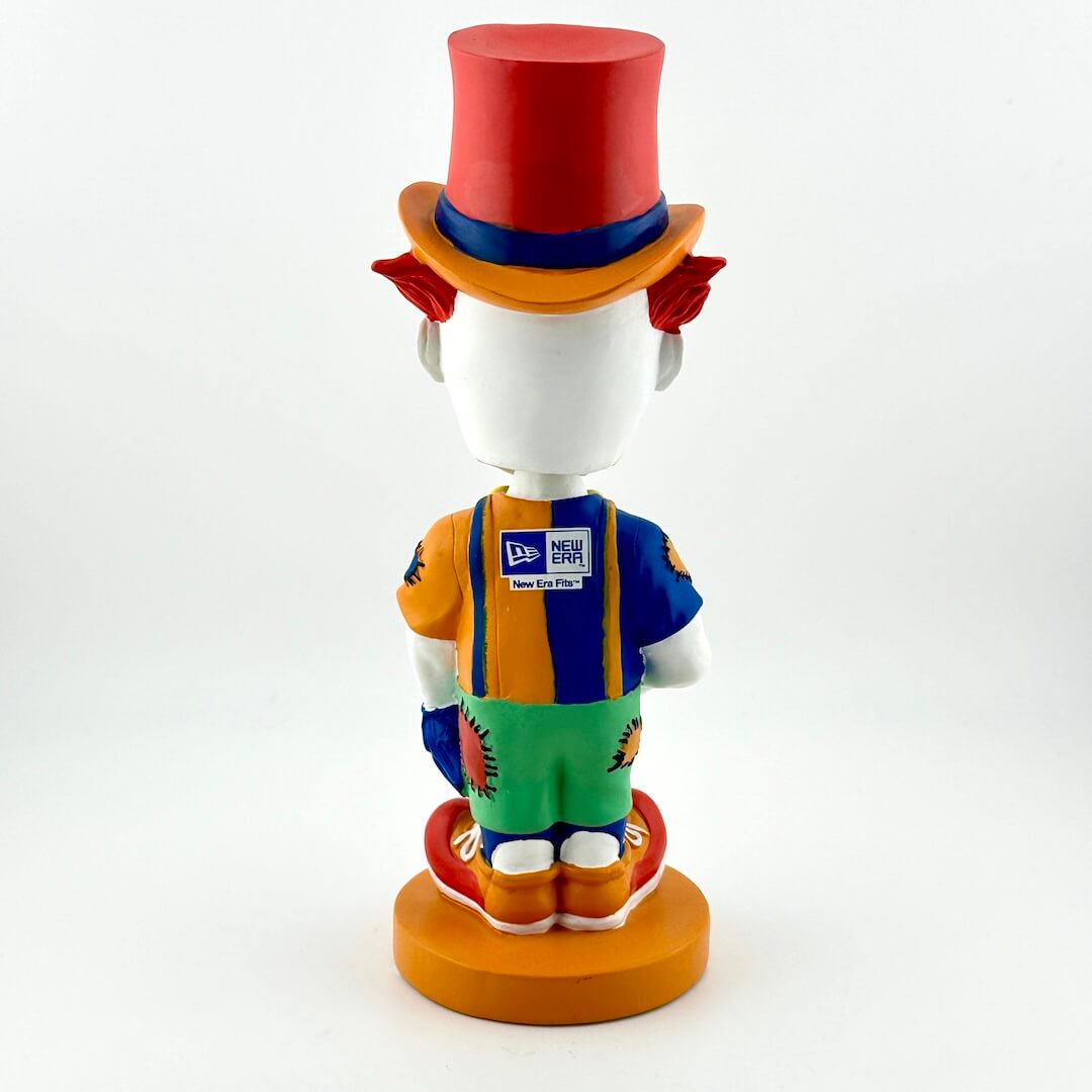 Colorful clown figurine with a red top hat and striped overalls on a white background