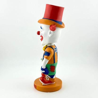 Colorful clown figurine with a red top hat on a white background