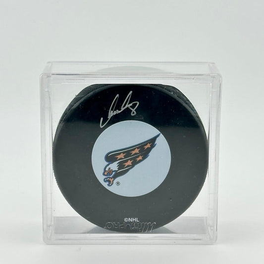 Hockey puck signed with silver marker inside clear plastic square display case. Eagle logo in center. 