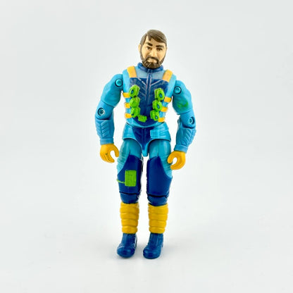 GI Joe action figure in blue flight suit with yellow and green accents, photographed on white background. 