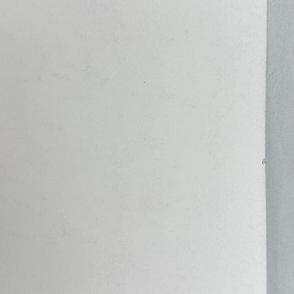 Spot of edge wear from reverse side on white background. 