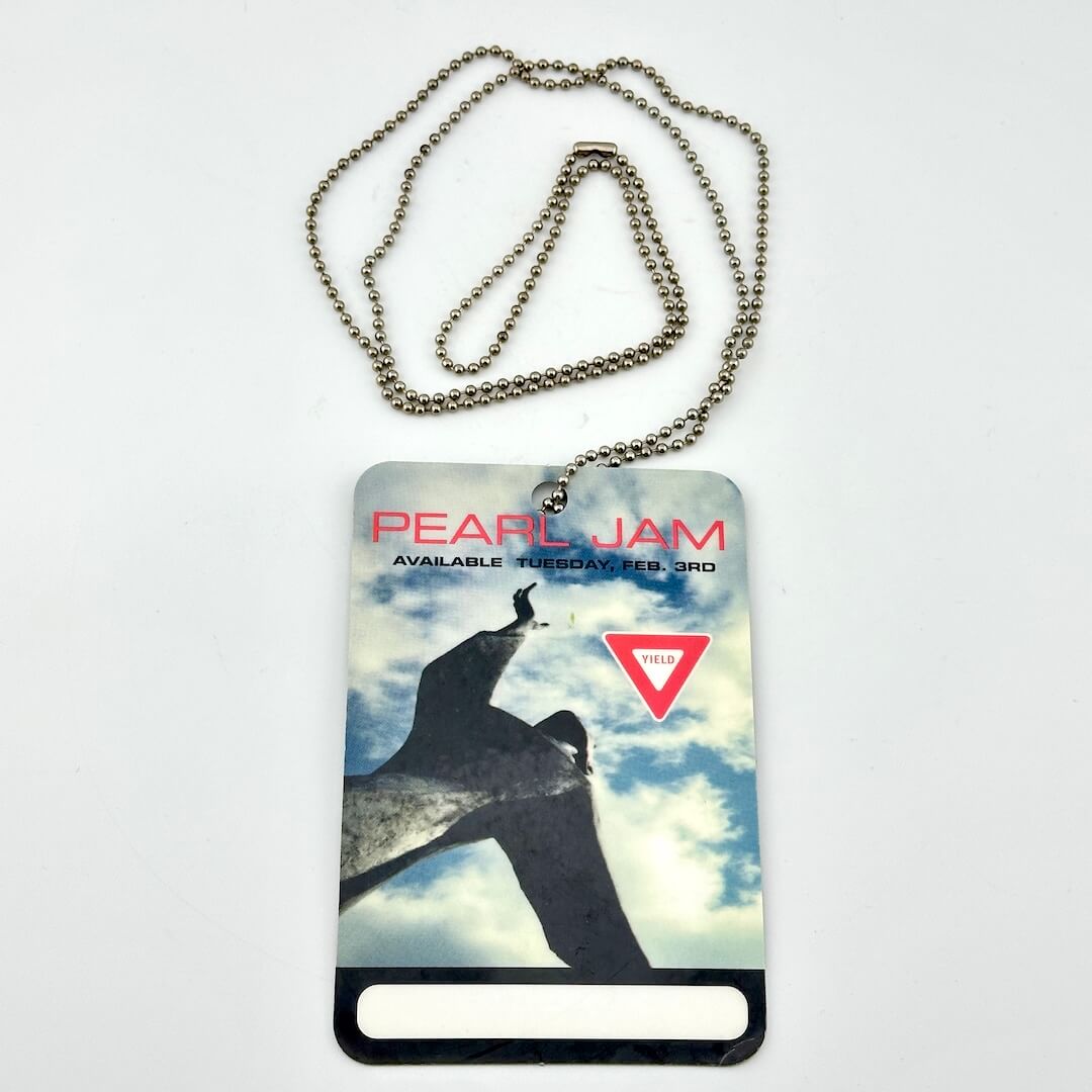 Pearl Jam album cover with a person jumping, chain, and 'Yield' sign on a white background