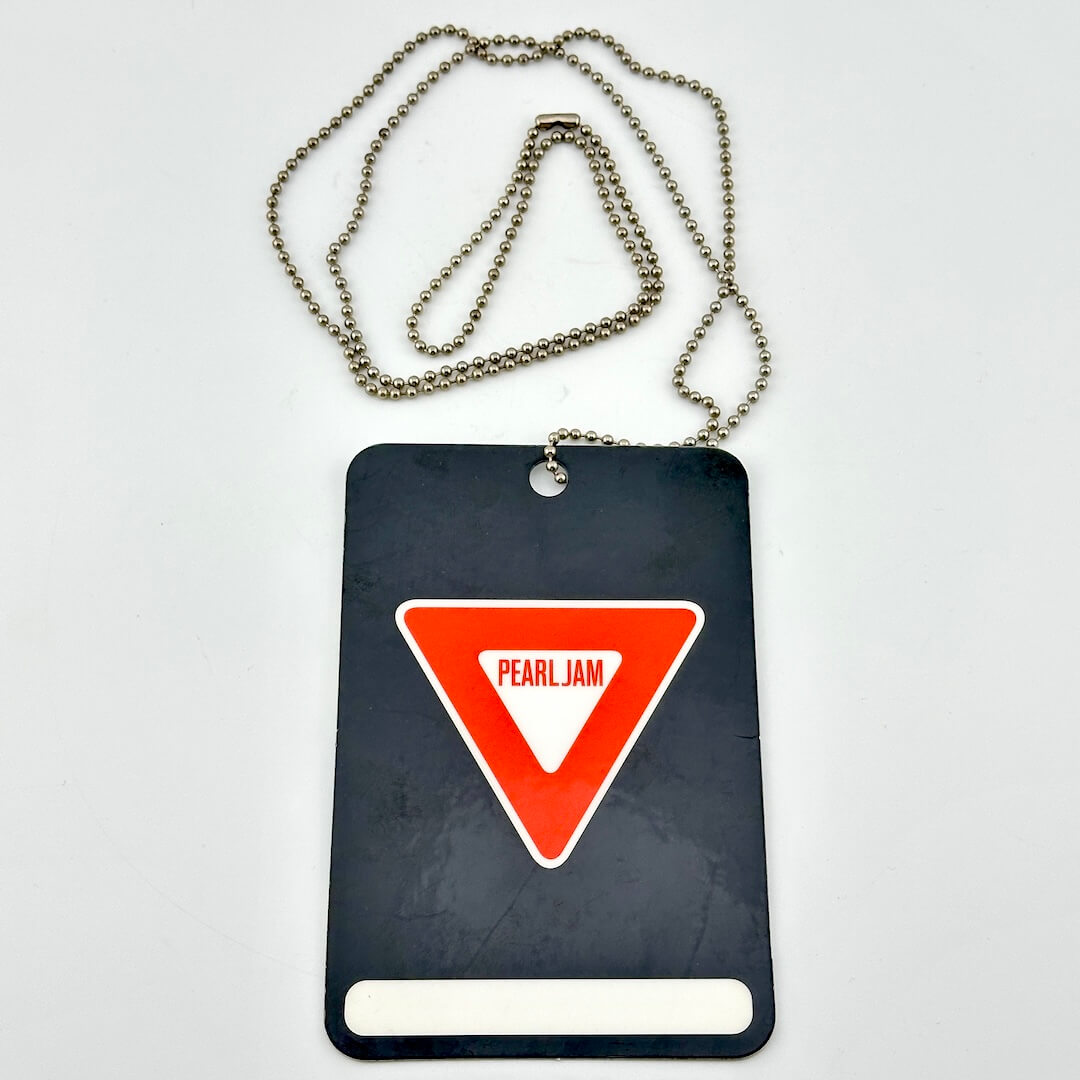 Black card with red triangle and 'Pearl Jam' logo on a white background