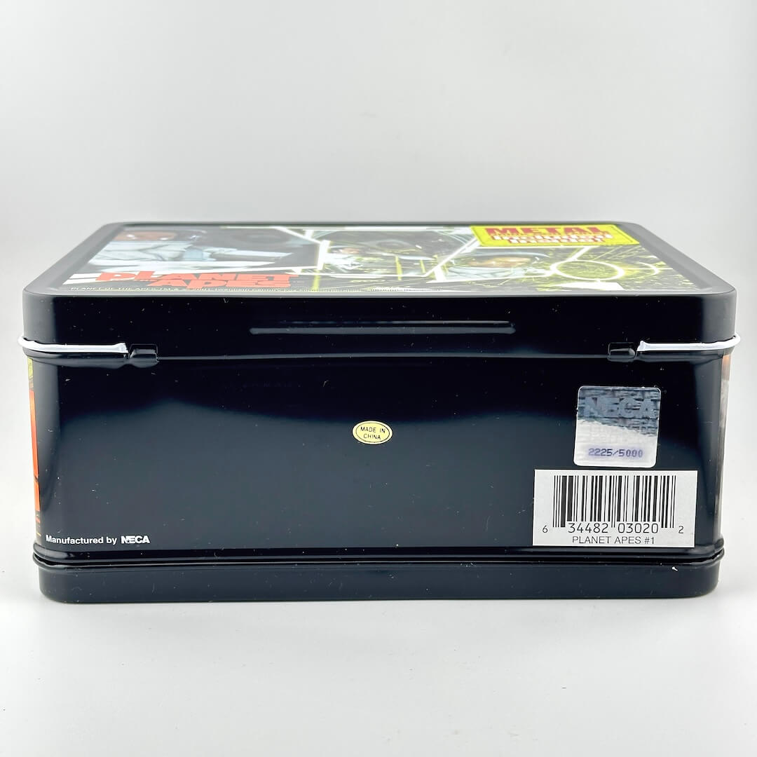 Bottom of black metal lunchbox with barcode and manufacturer stickers. 