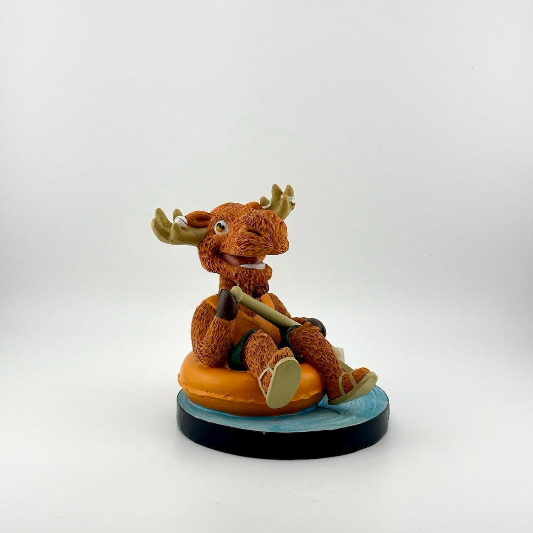 Orange anthropomorphic moose in vest & sandals floating in inner tube with bat as oar. Baseball in horns.